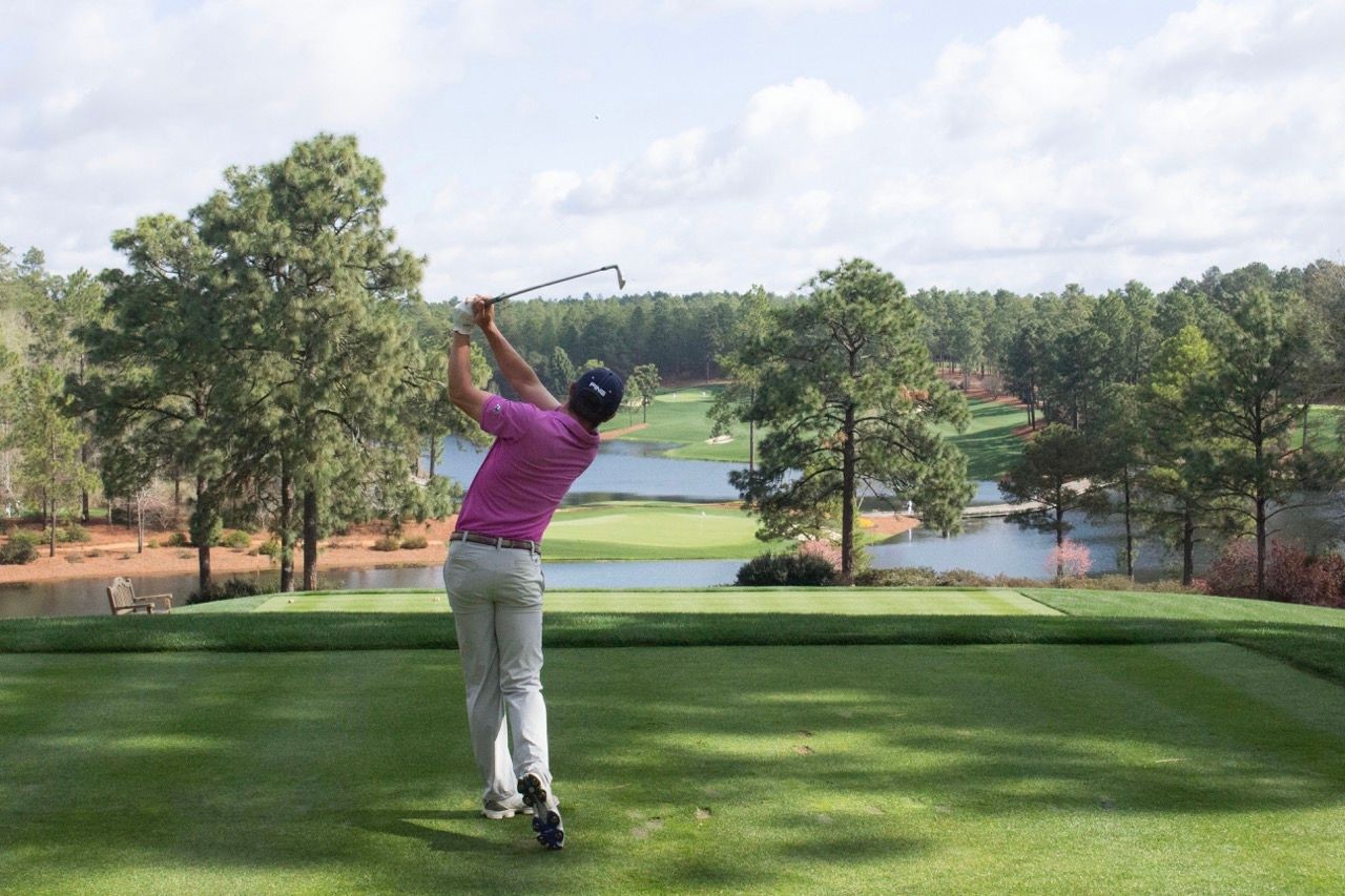 Golfer looking thoughtfully at the course, highlighting the mental aspect of learning golf