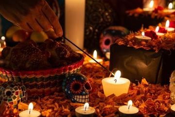 Ofrenda with candles, flowers, and photos