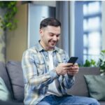 Man using a smartphone at home.