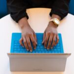 Hands reaching out to type on a tablet keyboard, symbolizing different learning approaches