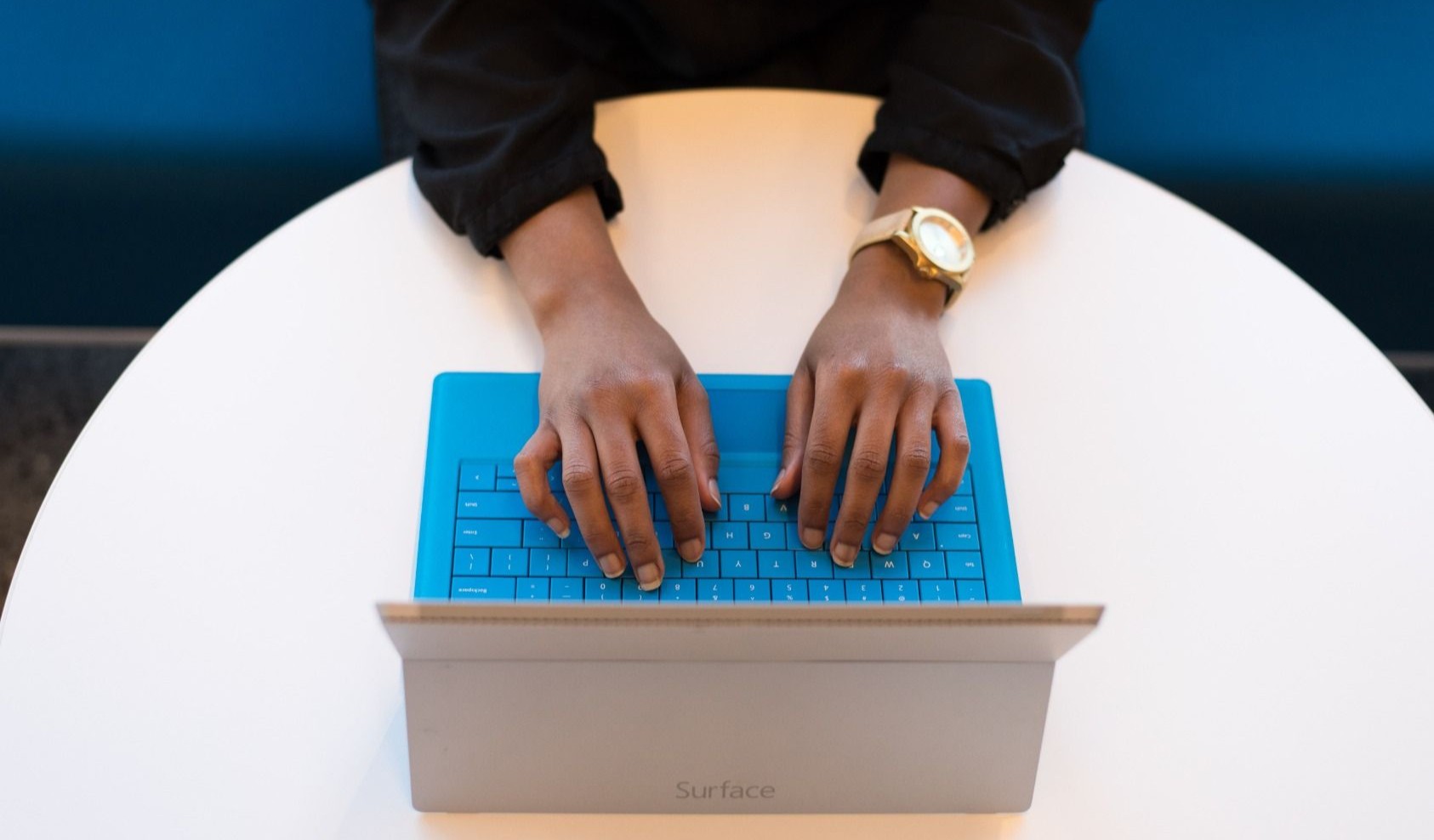 Hands reaching out to type on a tablet keyboard, symbolizing different learning approaches