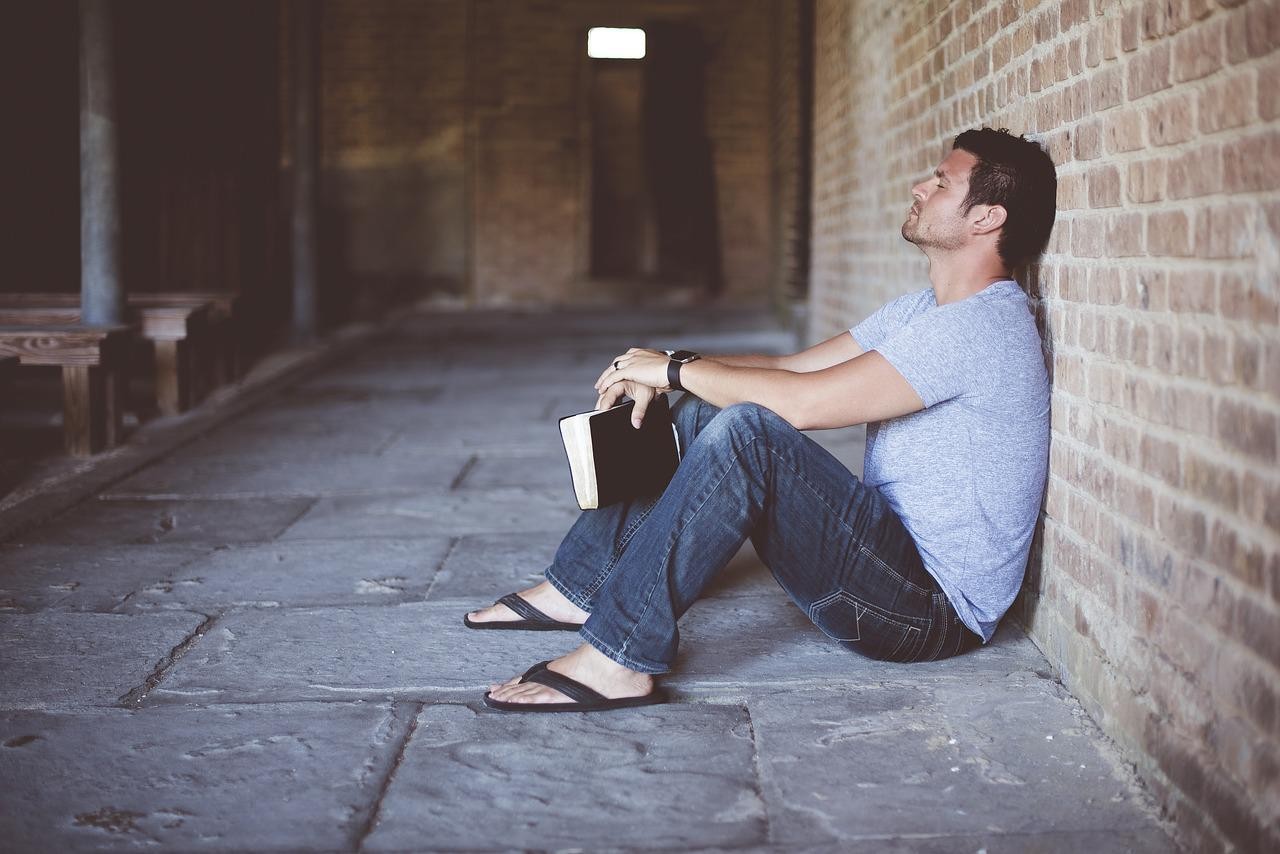 A person happily pointing at a Spanish textbook, illustrating the approachable nature of learning Spanish for English speakers.