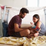 Father reading a book with daughter in a bedroom, one of the best Spanish books for beginners