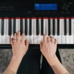 Hands playing chords on a piano keyboard, showcasing hand independence.