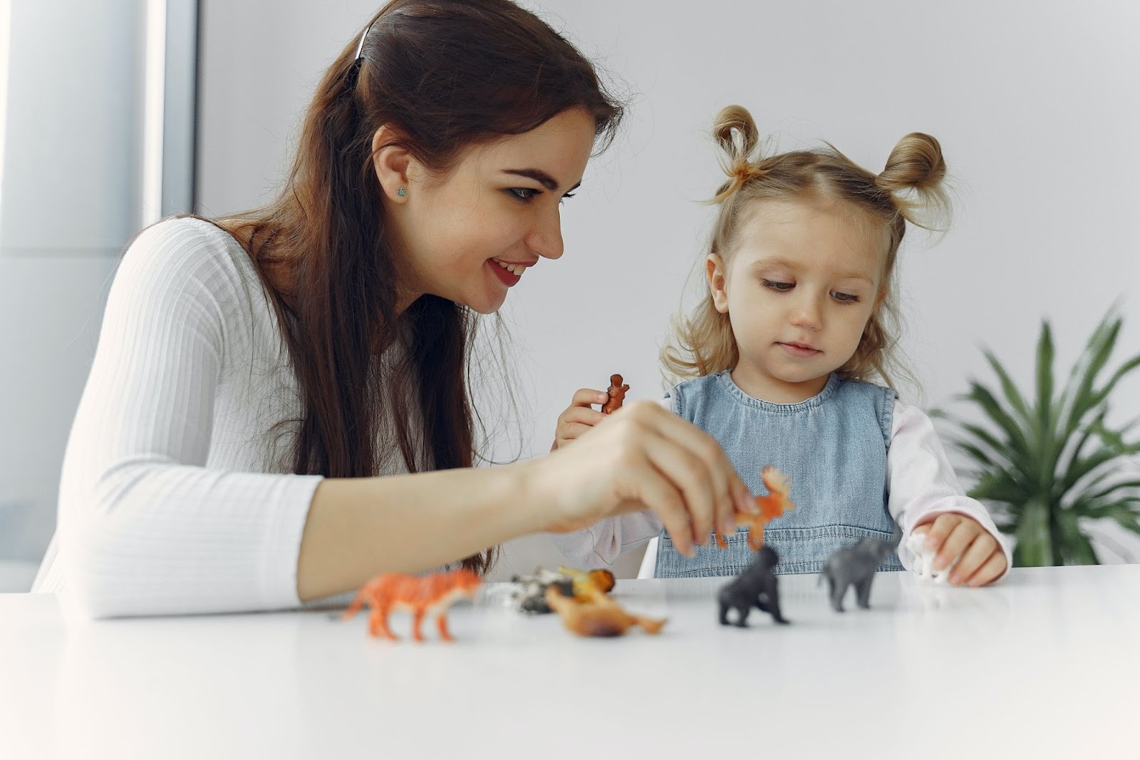 A teacher engaging with a child in a classroom setting, showcasing playful learning.