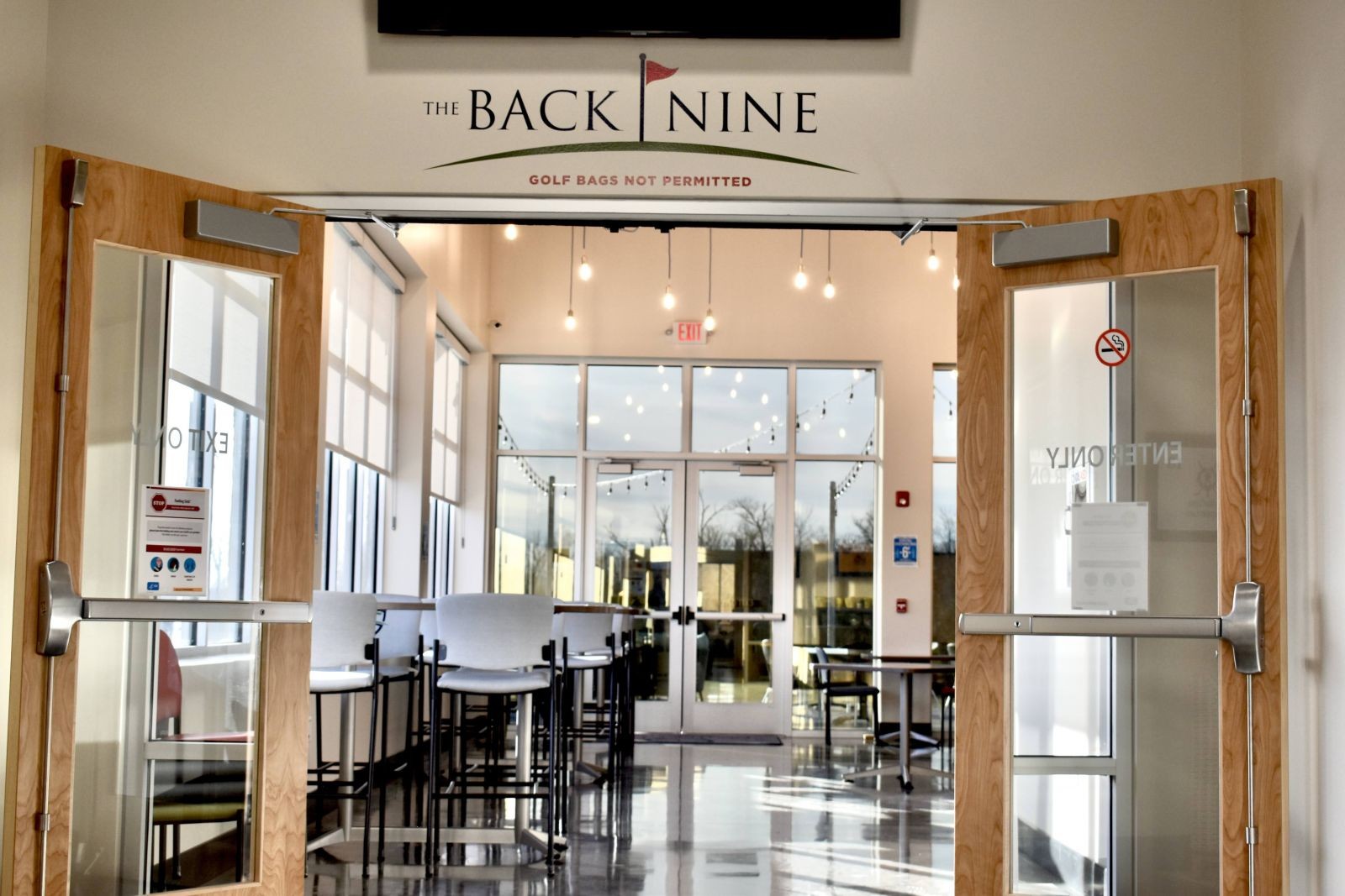 Exterior view of The Back Nine Restaurant entrance, showcasing its welcoming facade and hinting at a pleasant dining atmosphere.