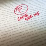 Professor's feedback on student paper with a failing grade and the question 'Where did you learn to write like this? Come see me?' highlighting the importance of learning to write and seeking feedback.