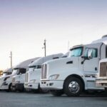 Row of White Fleet Big Rig Trucks