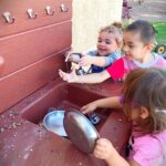 Children engaging in outdoor play at a learning center, fostering physical activity and social skills.