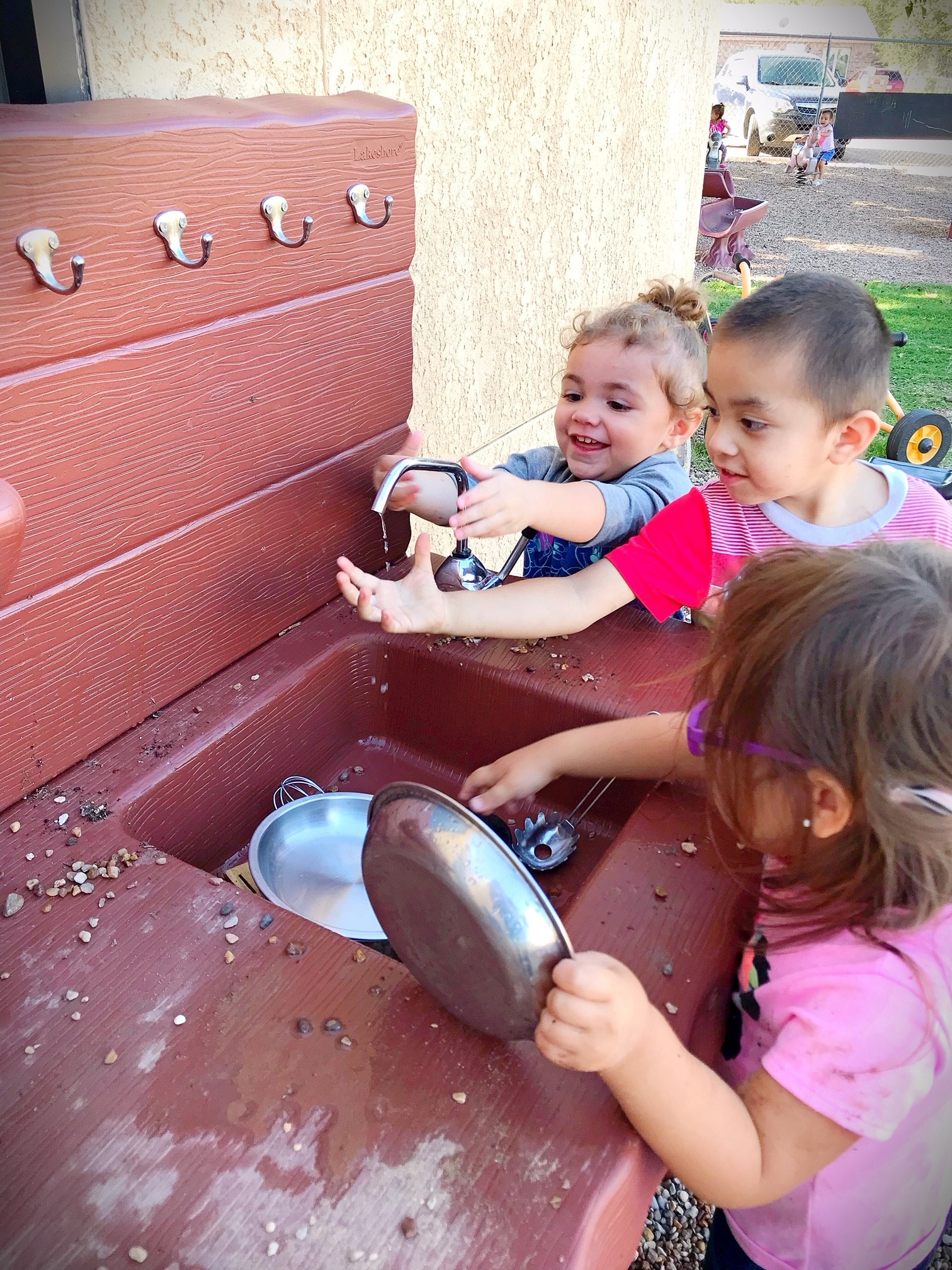 Children playing outside at an early learning center, engaging in outdoor activities