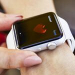 An Apple Watch displaying a heart symbol, illustrating mobile health technology for heart monitoring