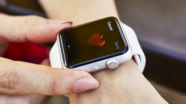 An Apple Watch displaying a heart symbol, illustrating mobile health technology for heart monitoring