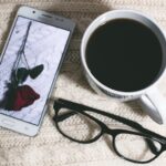 A phone, a pair of glasses and a cup of coffee, arranged on a table to illustrate spatial relationships.