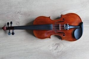 A violin resting on a white surface, showcasing its elegant curves and strings