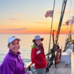 Interns and students engaging in water quality testing on a schooner, highlighting hands-on learning and teamwork.