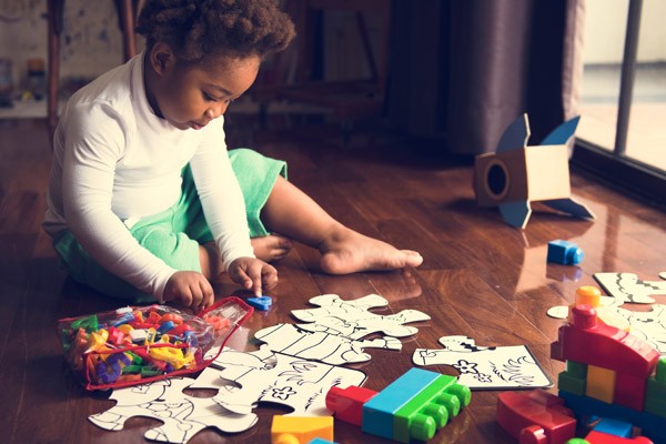 Child engaging in early learning activities with puzzles and alphabet letters