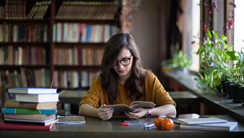 Person engrossed in a book, symbolizing a love for learning