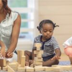 Preschool children playing with wooden blocks in the classroom.