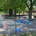 Children joyfully playing on the brightly colored playground at Little Lambs Learning Center, a safe and engaging outdoor play area for early childhood development in Maryland.