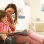 Mother sitting with child reading story indoors