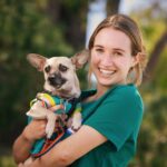 Veterinary student Lena Hoover gains hands-on learning experience holding Milo the chihuahua during a community clinic near Cal Poly.