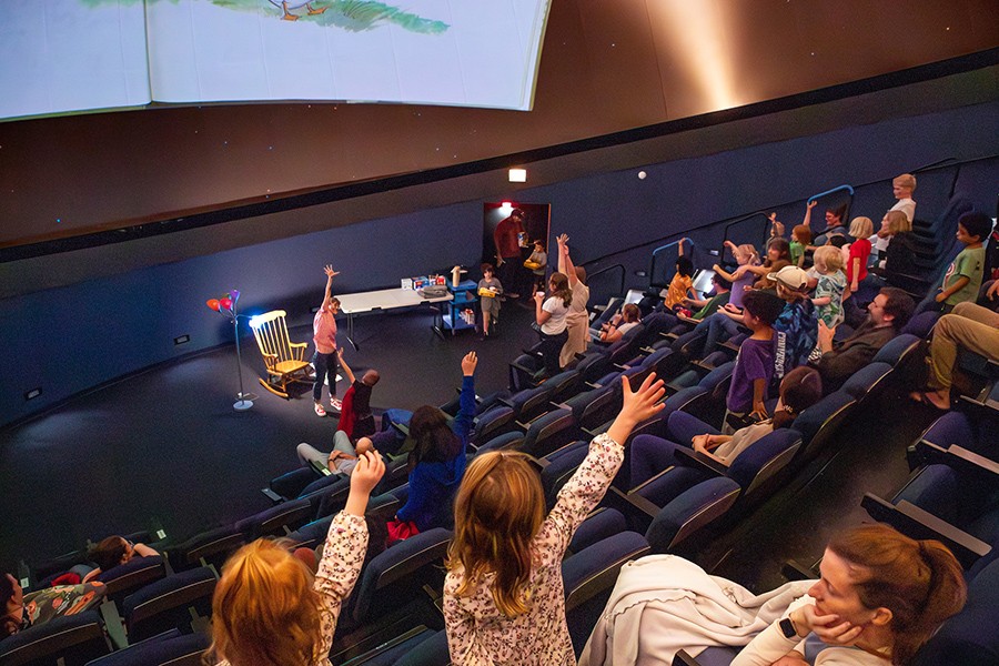 Enthusiastic crowd enjoying Storytime Under the Stars at Challenger Learning Center of Tallahassee, a family-friendly STEM event