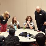 Cardinal Learning Bridge Academy students and their mentors engage in a breakout session at the University of Louisville Belknap campus, highlighting mentorship opportunities within the program.