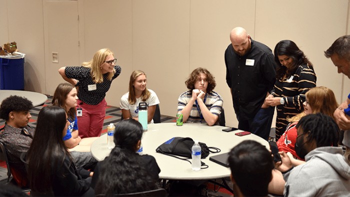 Cardinal Learning Bridge Academy students and their mentors engage in a breakout session at the University of Louisville Belknap campus, highlighting mentorship opportunities within the program.