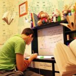 A person thoughtfully looks at study materials, representing the decision to learn Portuguese after Spanish and the considerations involved in mastering a new language.