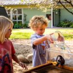 Students participating in outdoor water activities during a hands-on progressive learning lesson at The School of Rose Valley preschool program