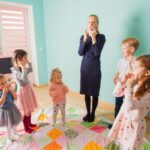 Preschool teacher and children singing learning songs in a classroom setting