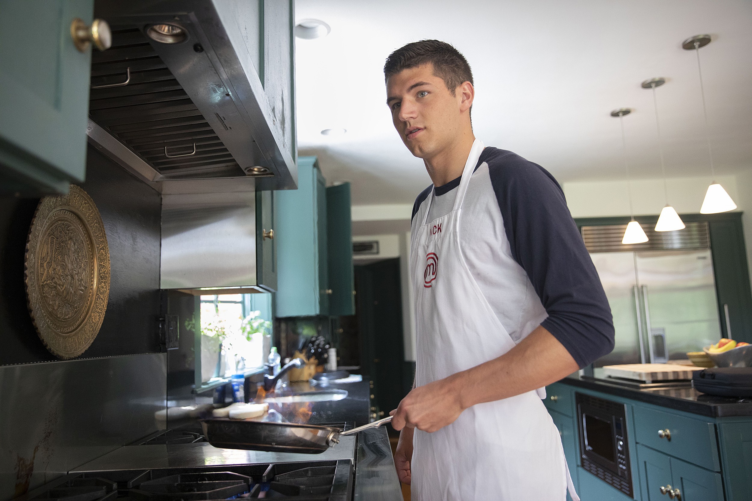 Nick DiGiovanni in his modern Milton kitchen, confidently preparing a meal, highlighting his culinary passion