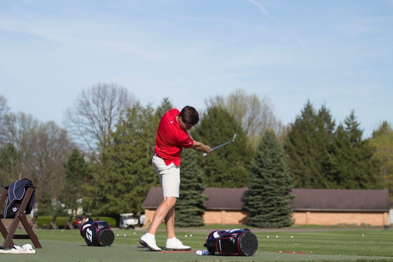 Golfer practicing their swing at the driving range, focusing on proper form and technique.