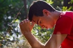 Young man resting head on hands