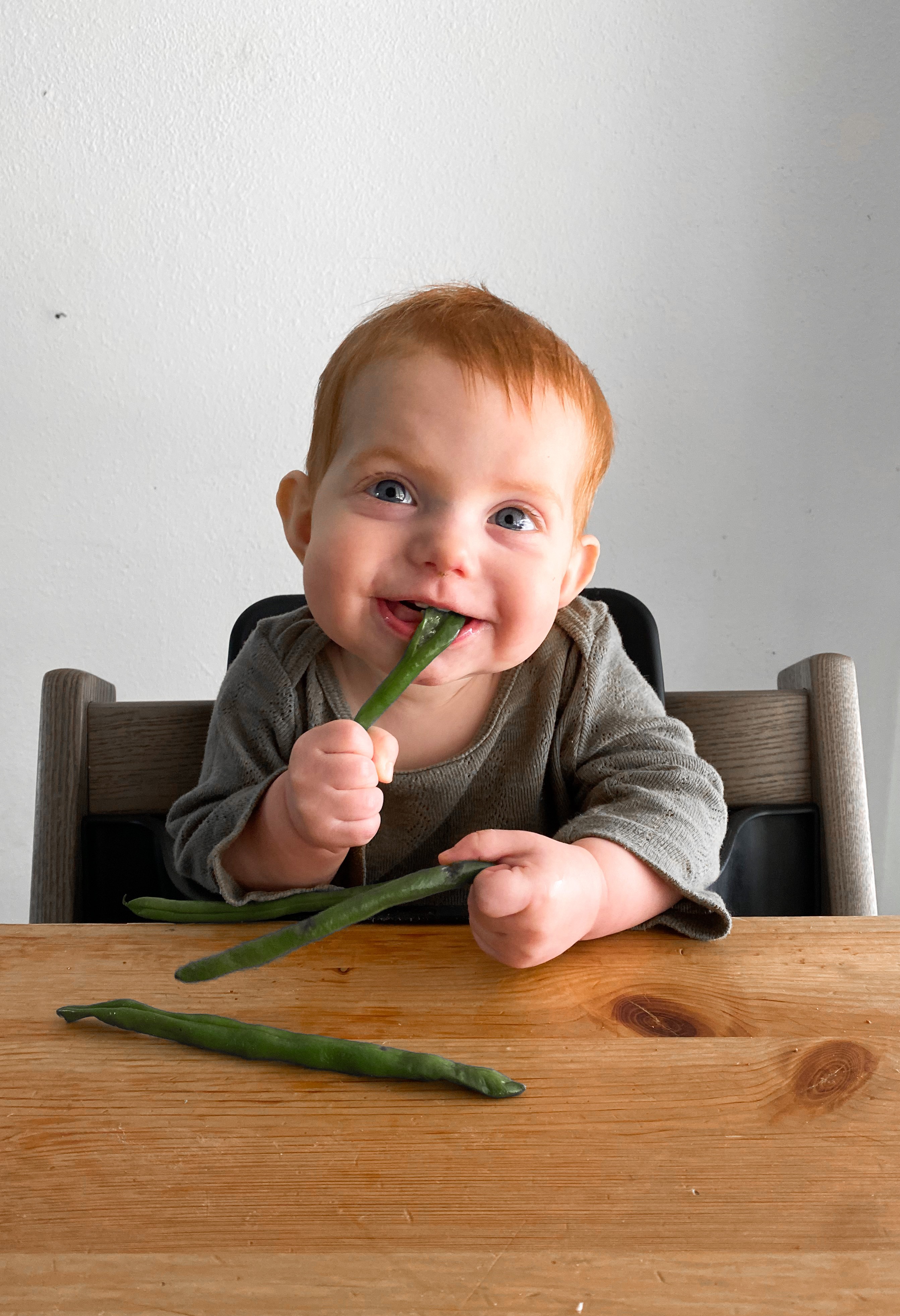 Baby eating asparagus to stimulate chewing