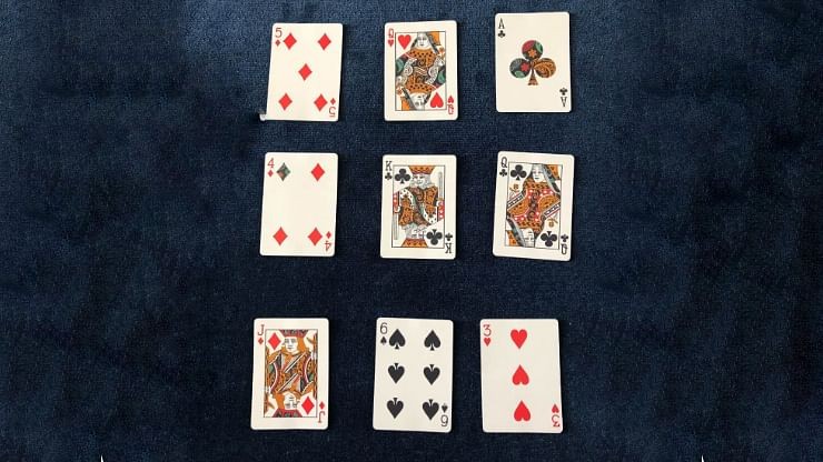 9 playing cards from the Dapper Deck from Vanishing Inc. are used for a mind reading card trick performed on a blue close-up mat
