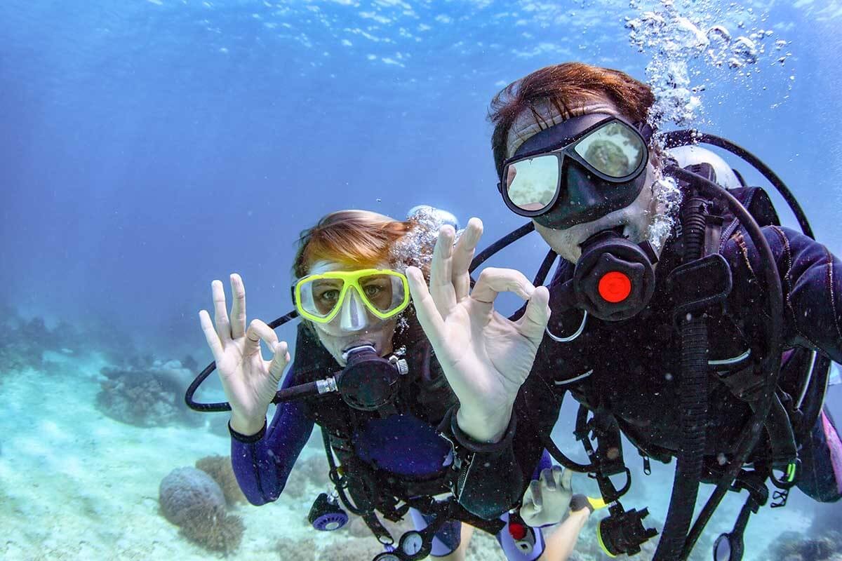 Diver giving the okay sign underwater indicating safety is assured