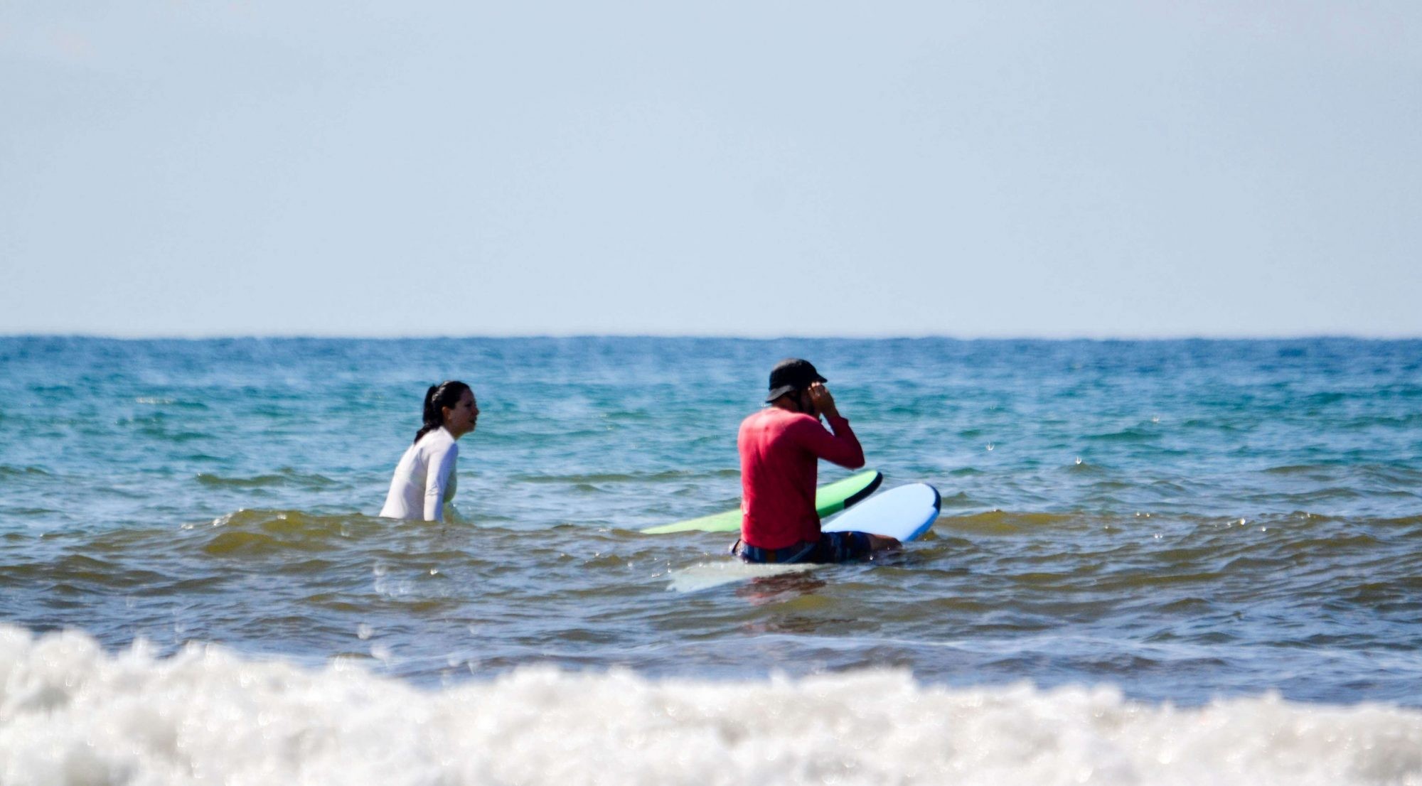 Surfers sitting in the lineup for bluegreen waves