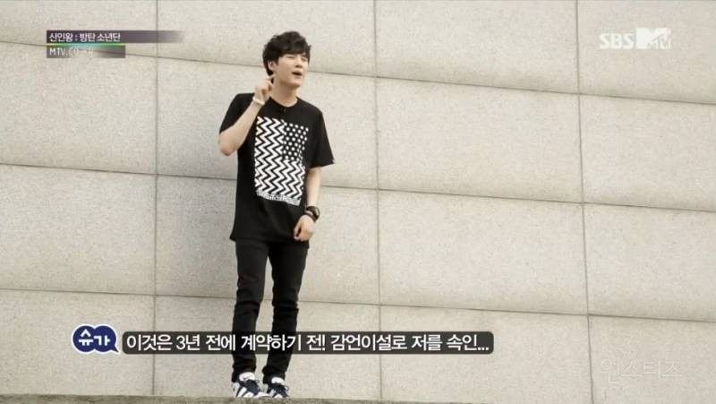Suga playing the piano during a concert performance, showcasing his dedication to his craft