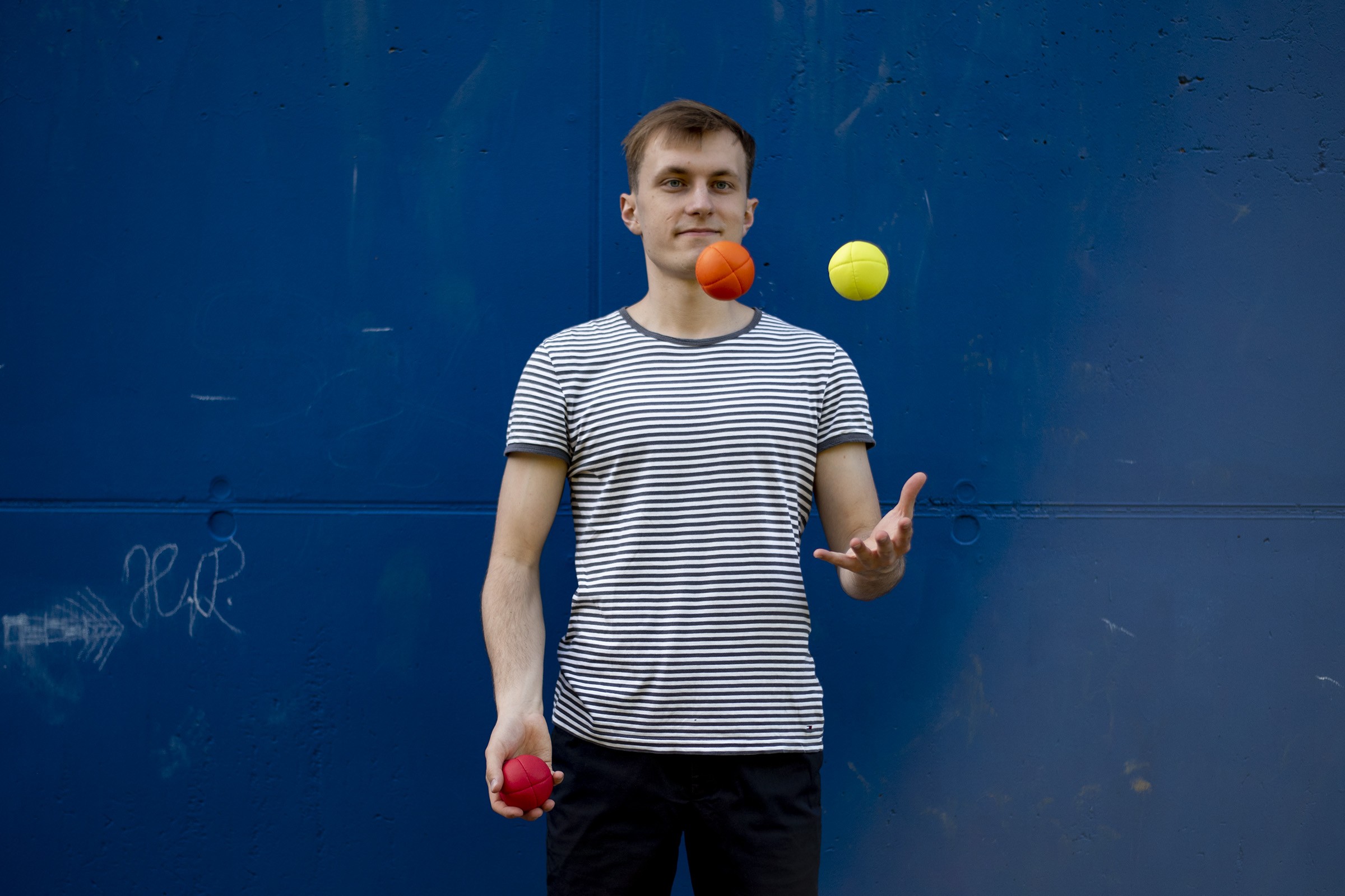 Three hands juggling balls in the air