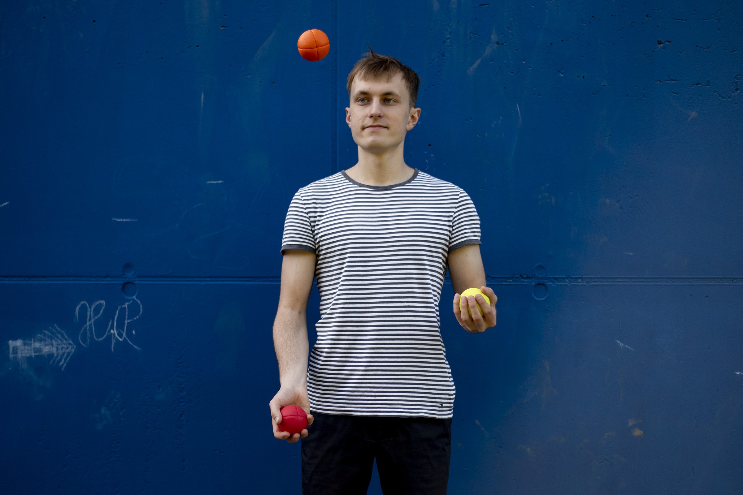 Hand catching a yellow juggling ball