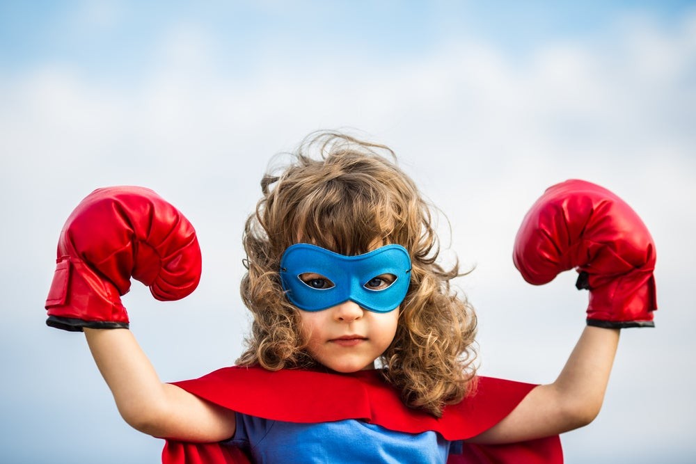 A girl imaginatively dressed as a superhero, symbolizing creative expression and imaginative play