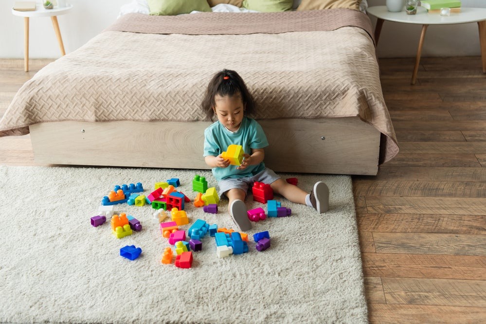 A girl creatively playing with building blocks, showcasing imagination and spatial reasoning