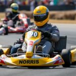 A young racer driving a go-kart on a track, demonstrating early racing skills