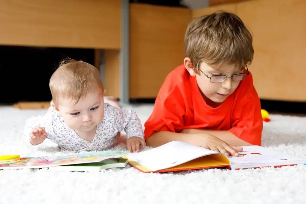 Child excitedly pointing to letters in a colorful book