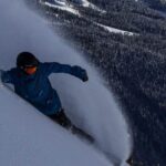 Snowboarder gliding through powder snow