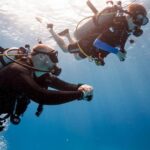 Scuba diving students in a pool learning mask clearing techniques