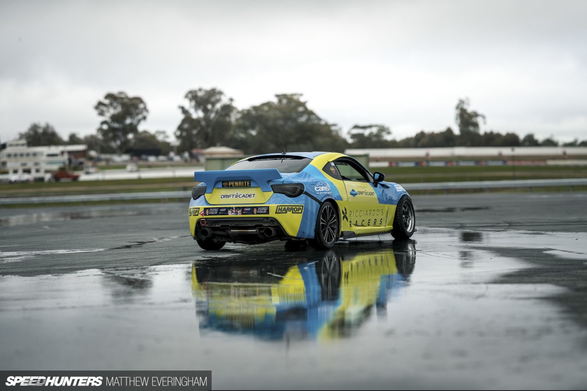 Drifting car sliding sideways on a track, showcasing controlled oversteer