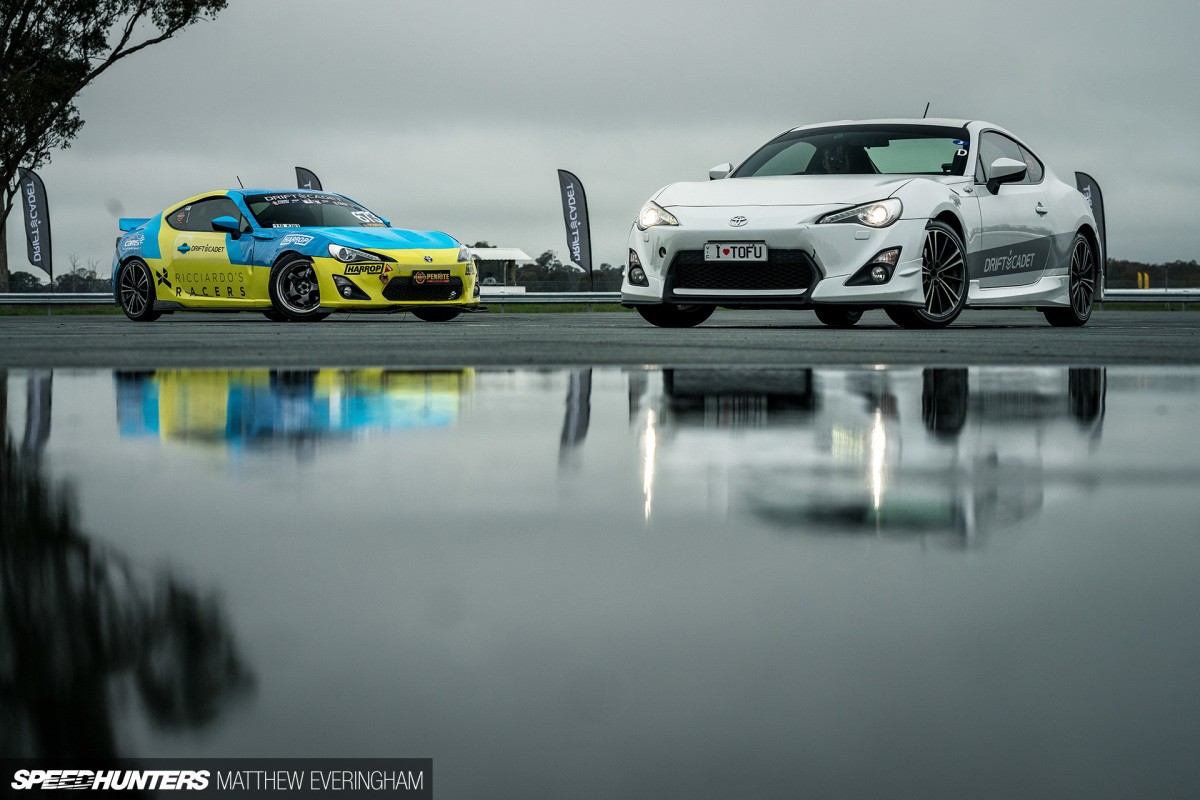 Two cars tandem drifting in close proximity, showcasing advanced drifting skills