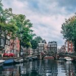 A picturesque Dutch city with canals, cars, bikes, and buildings, highlighting the urban landscape and lifestyle